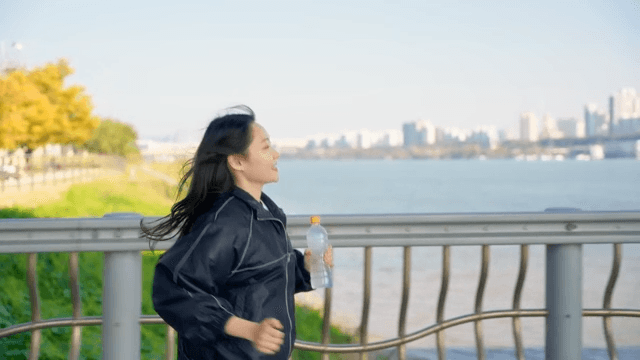 Woman drinking water while jogging