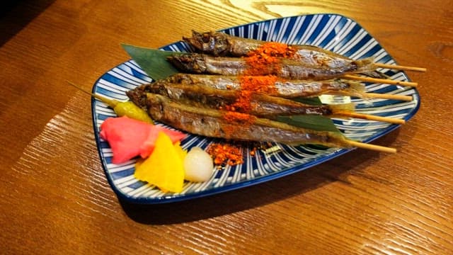 Grilled shisamo skewers neatly placed on a plate