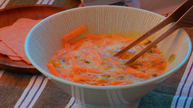 Put carrots, green onions, and eggs in a bowl and mix with chopsticks