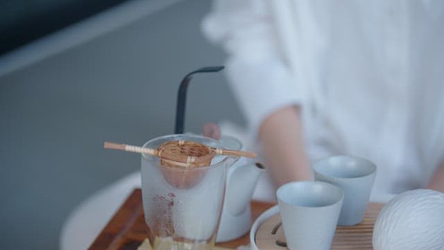 Person Leisurely Brewing Tea Indoors