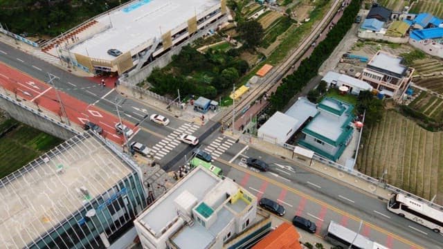 Road with pedestrians and vehicles near a train station