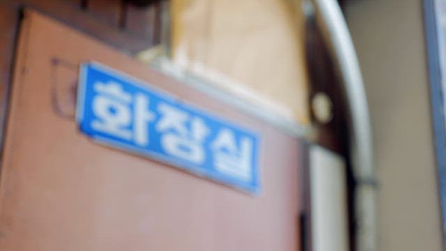 Restroom sign on a wooden door