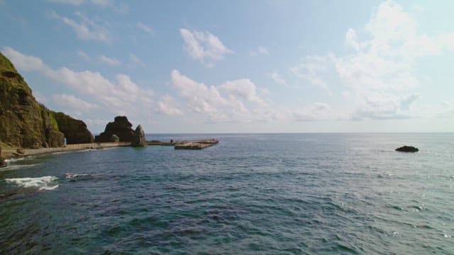 Rocky coastline with a pier and calm sea