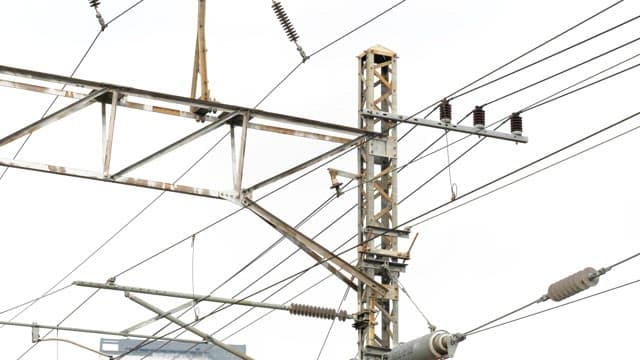 Catenary wires and metal structures visible on the tracks