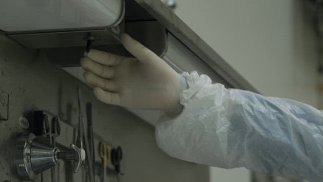 A gloved hand adjusting a surgical light