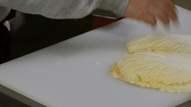 Preparing cabbage on a white cutting board in the kitchen
