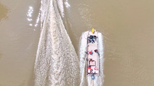 Boats cruising down a river on a sunny day