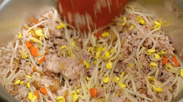 Seasoned bean sprouts and rice mixed in a brass bowl
