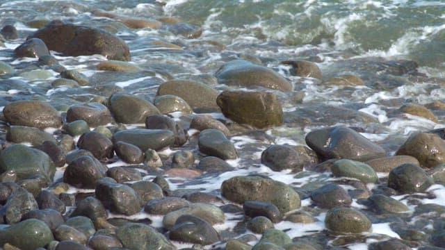 Waves gently washing over smooth stones