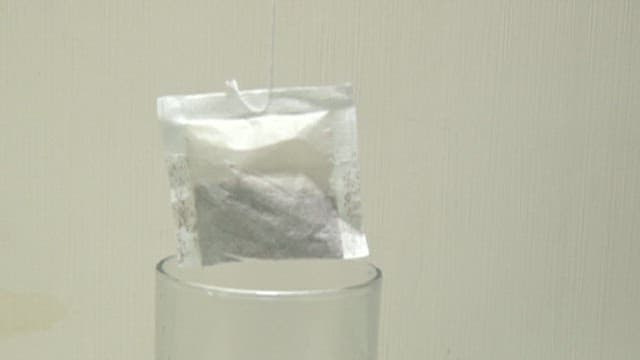 Green Tea Bag Steeping in a Clear Glass Cup