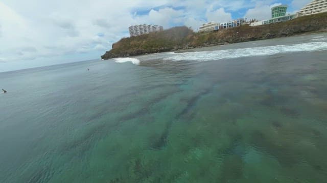 Coastal view with surfers and buildings