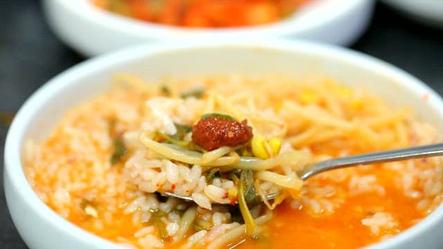 Spoonful of rice in kimchi stew with bean sprouts