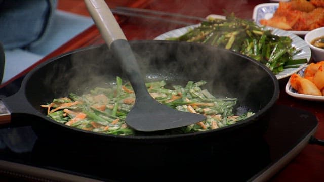 Delicious chive pancakes cooked in a hot frying pan