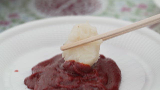 Dipping Boiled Potatoes with Chopsticks in Red Pepper Paste