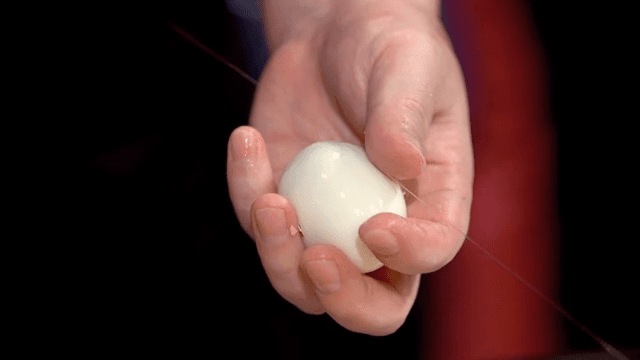 Slicing a peeled boiled egg with a thread