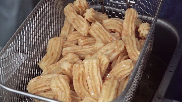 Churros being fried in hot oil