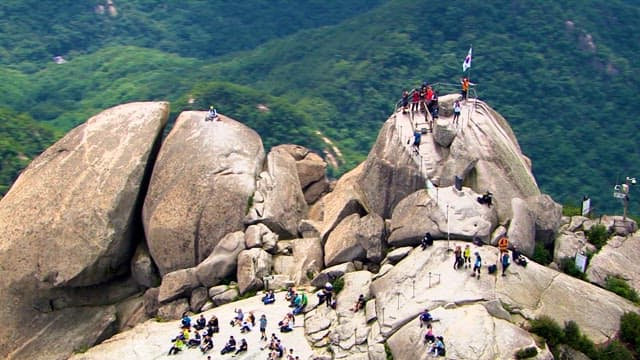 Hikers Climbing a Rocky Mountain on a Sunny Day