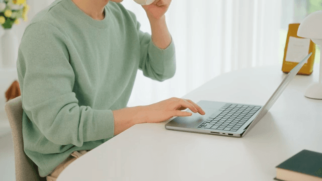 Man using laptop on the white table