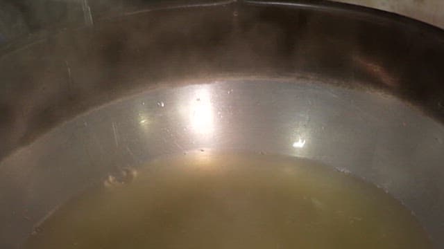 Broth being poured into a pot