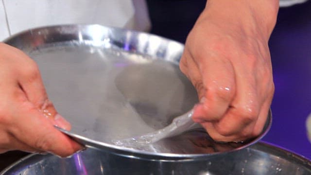 Chef removing cooked starch batter from a tray