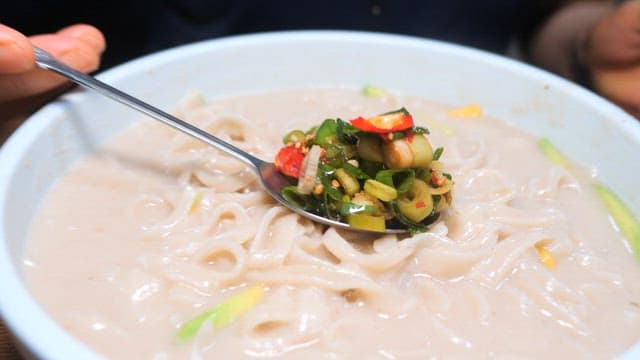 Noodles in cold soybean soup with various vegetables and seasonings