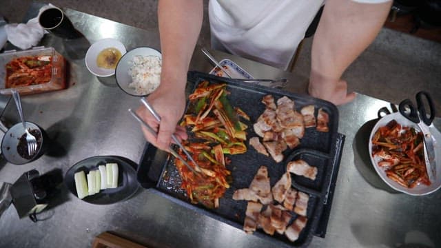 Grilling pork belly and green onion kimchi in a pan