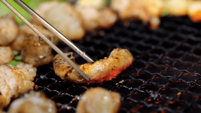 Grilled beef small intestines picked up with chopsticks