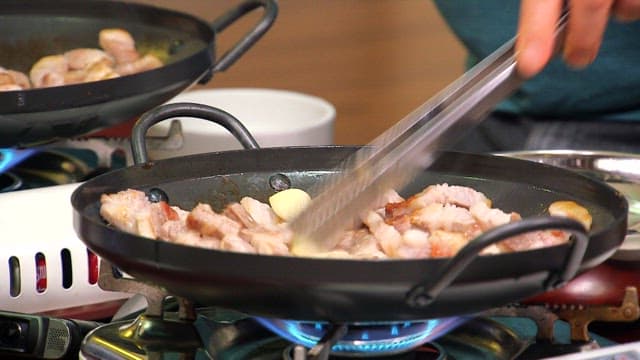 Cooking pork belly with garlic in a pan