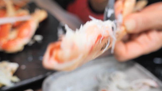 Extracting well-cooked crab meat with spoon
