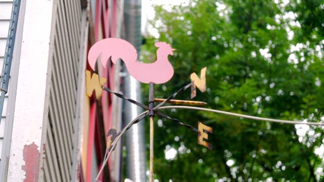 Red rooster weather vane on a building