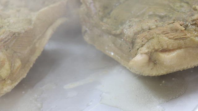 Boiled meat being taken out from the pot in the kitchen