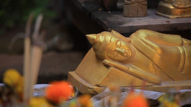 Golden Buddha statue with incense and flowers