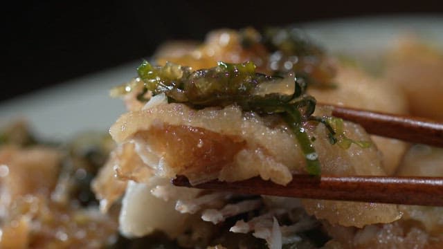 Inside of freshly fried fish tempura picked up with chopsticks