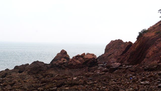 Secluded rocky shore with a calm sea in the background