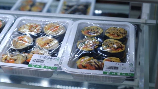 Kimbap in a plastic container displayed on a market shelf