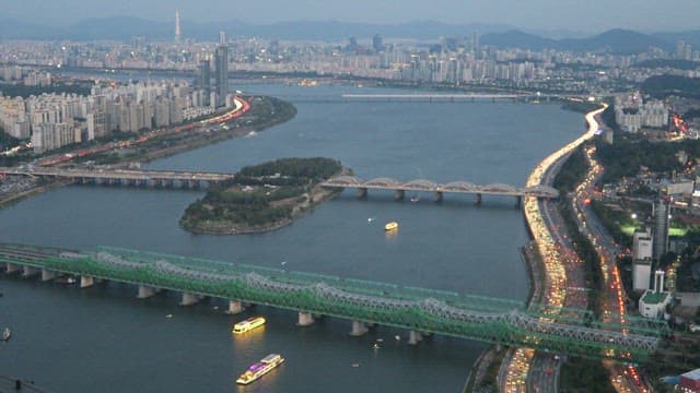 Crowded Carriageway and Bridge over River at Dusk