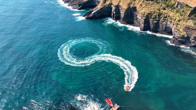 Boats creating patterns on clear blue sea