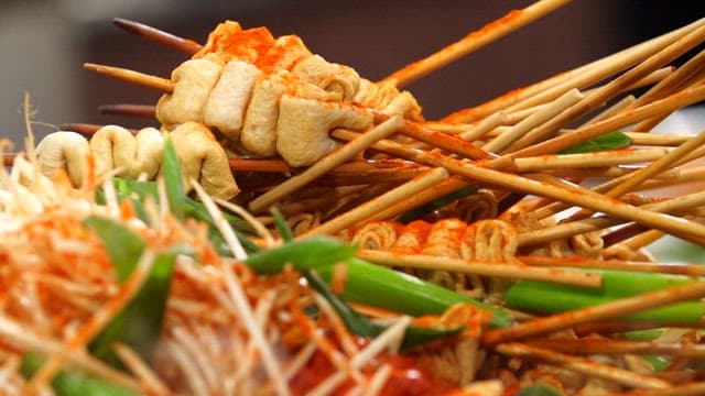 Spicy fish cake skewers with bean sprouts and green onions