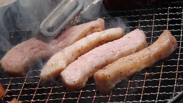 Delicious pork neck grilling on a hot barbecue grill outdoors