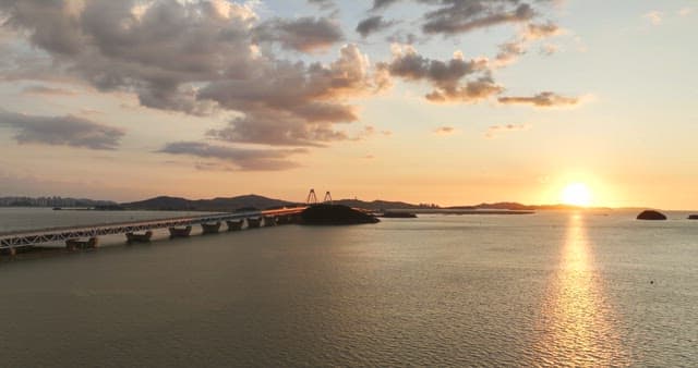 Sunset over a bridge and calm sea