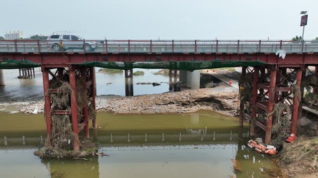 Vehicles Crossing a Bridge over a River
