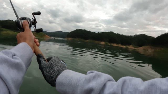 Man casting a fishing rod in a calm river