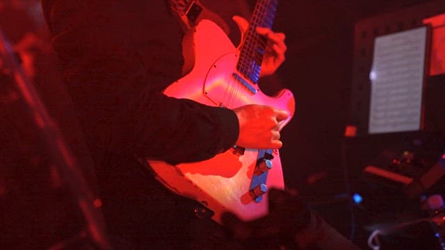 Person playing an electric guitar on stage