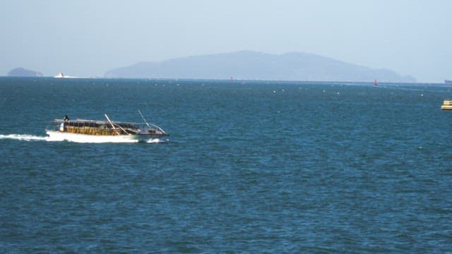 Fishing boat cruising on a calm sea under a clear sky