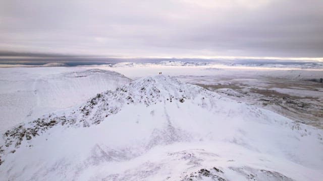 Snow-covered mountains under a cloudy sky