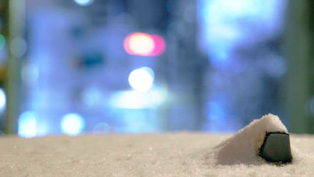 Snow-covered structures against a dim light background