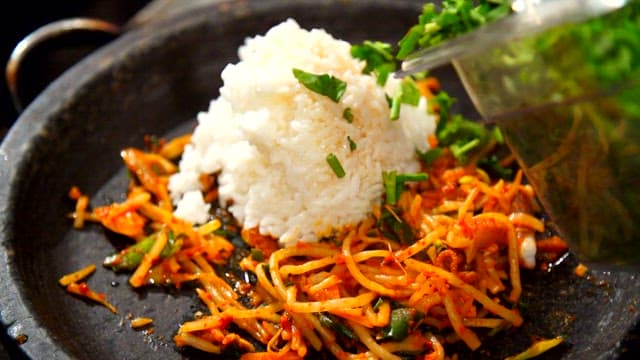 Rice and various vegetables prepared on a hot plate