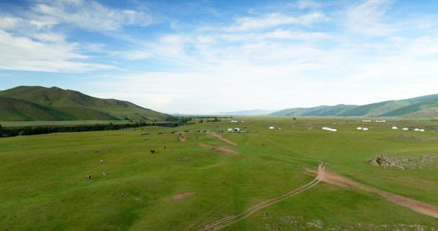 Expansive green plains with distant mountains