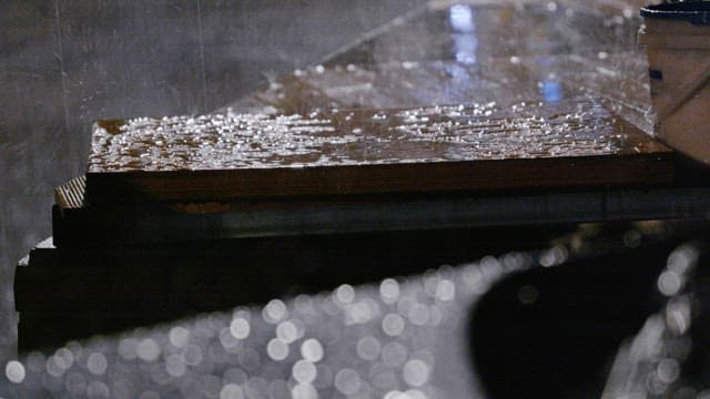 Rain falling on wooden deck at night