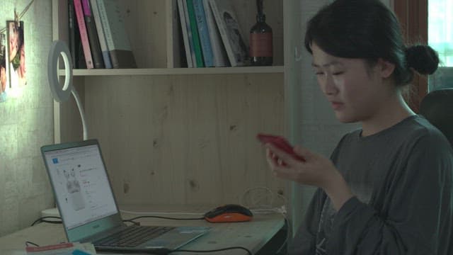 Woman doing internet shopping on laptop in her room at home